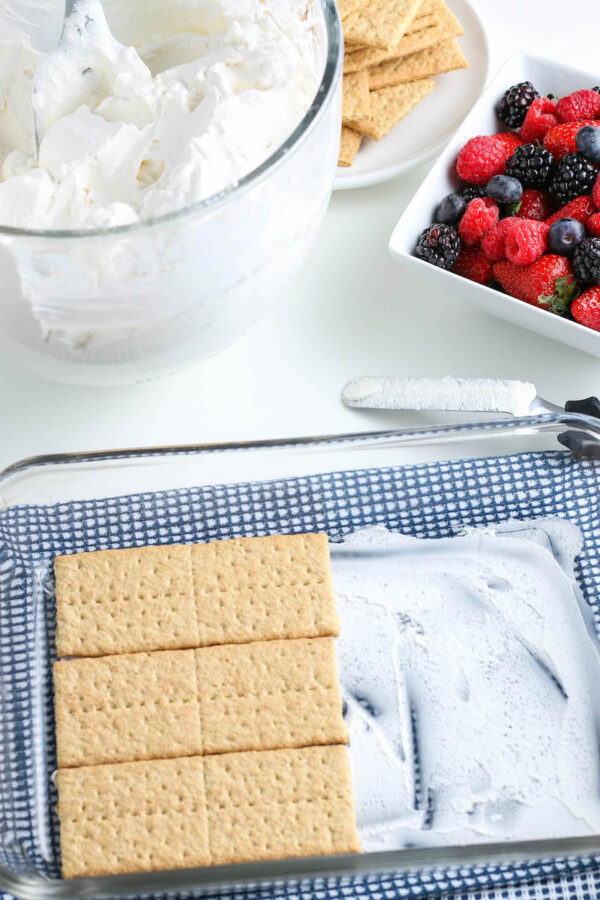 Adding a layer of graham crackers over the whipped cream.