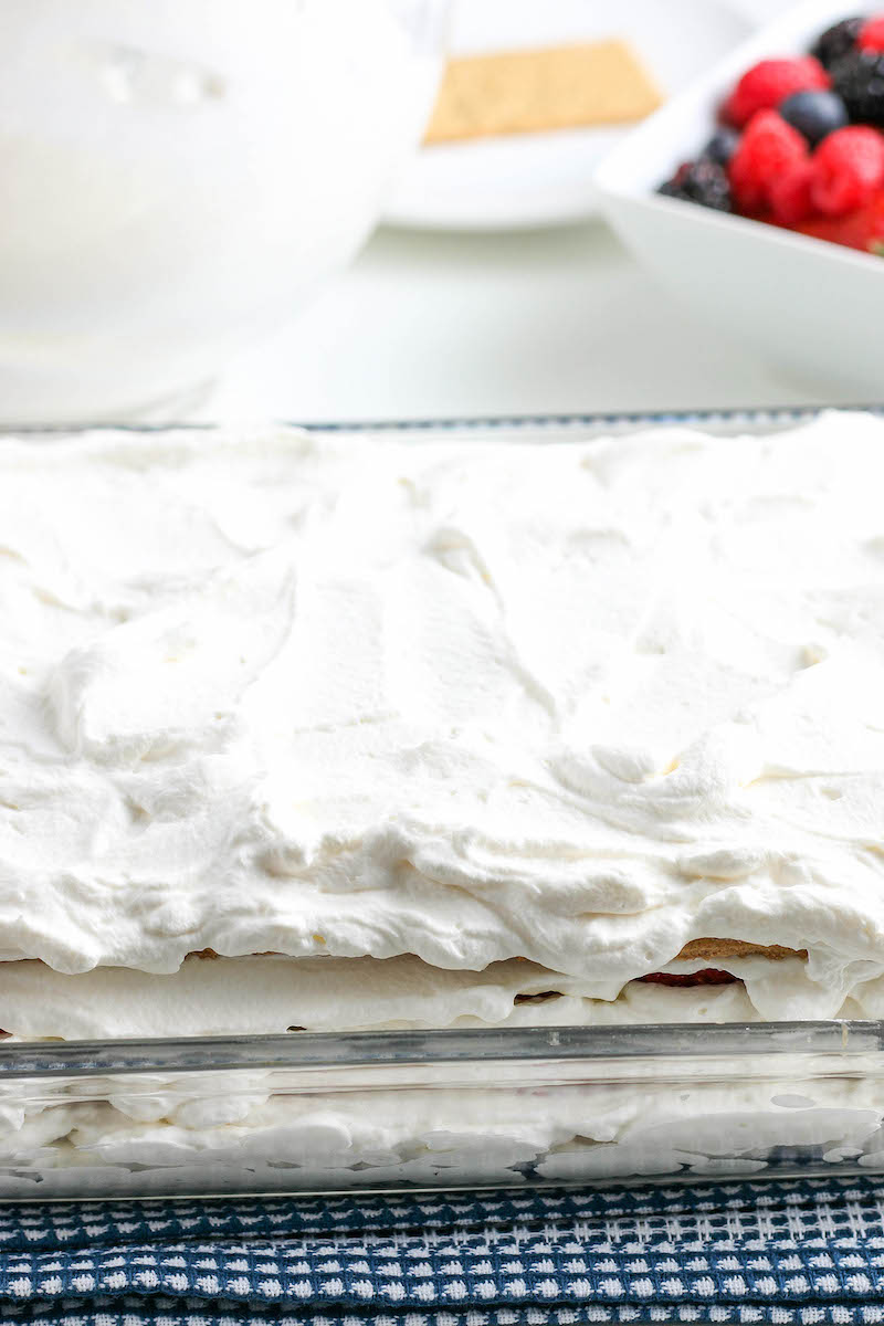 Pan of icebox cake with a top layer of whipped cream.