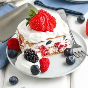 A square of icebox cake with whipped cream and berries on a plate