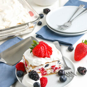 A layered slice of my berry icebox cake with more fresh berries as a garnish.