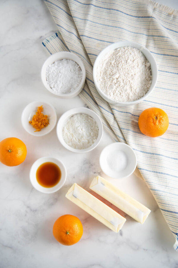 ingredients for shortbread cookies in bowls on a marble table.