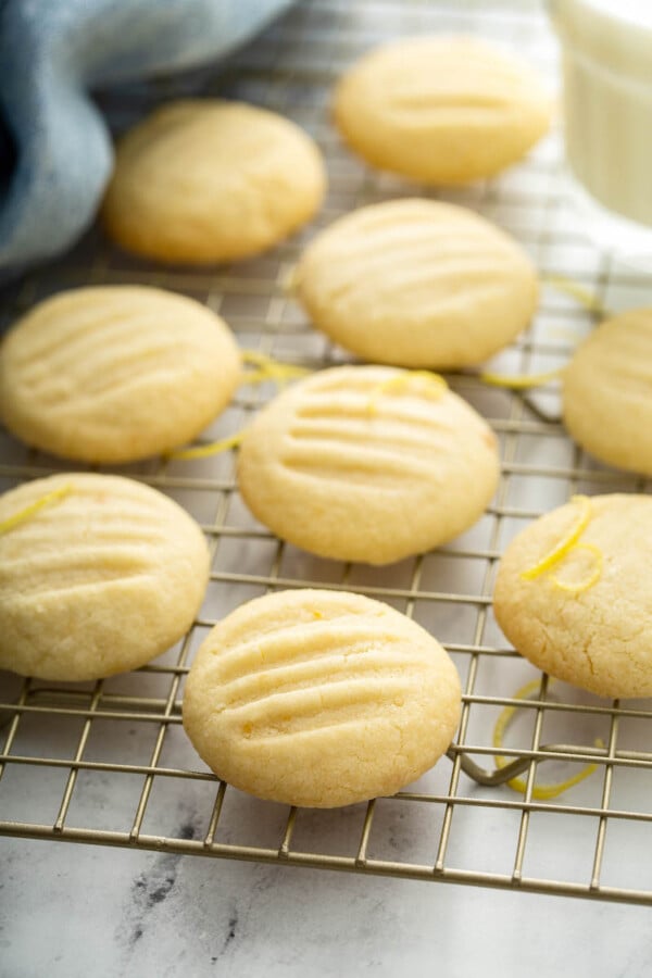 Up close image of shortbread cookies on a baking sheet with a tea towel.