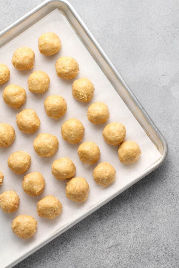 Truffles are on a cookie sheet with parchment paper. 