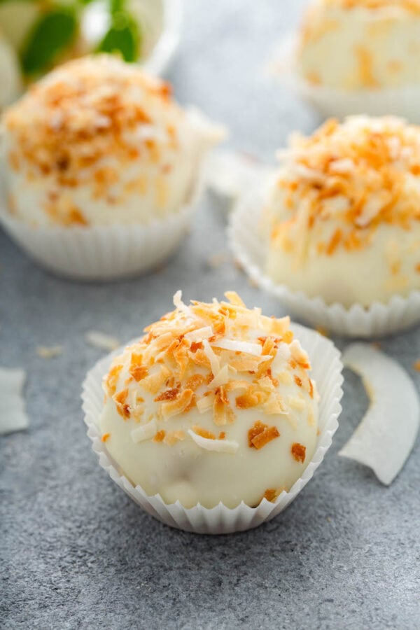 Up close image of truffles with coconut on top.