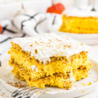 Slice of pumpkin ice box cake with cool whip topping, on a plate.