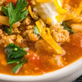 Up close image of turkey taco soup in a bowl with toppings.