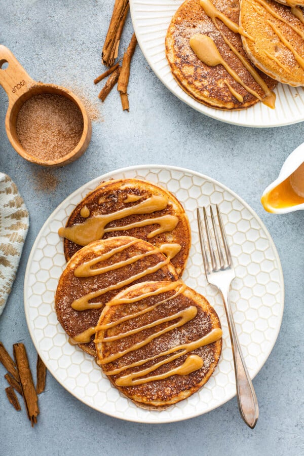 Churro Pancakes on a plate with cinnamon sugar on top with a fork.
