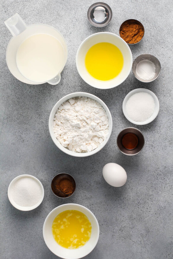 Ingredients for Churro Pancakes in bowls on a gray backdrop.