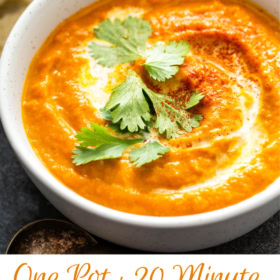 Up close image of creamy pumpkin soup in a bowl with cilantro on top with wording on the bottom for Pinterest.