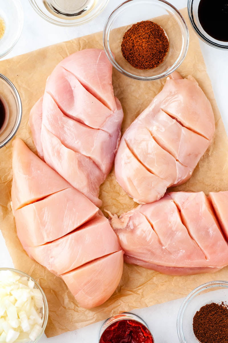 4 sliced chicken breasts on a cutting board.