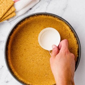 Measuring cup pressed into a graham cracker crust.