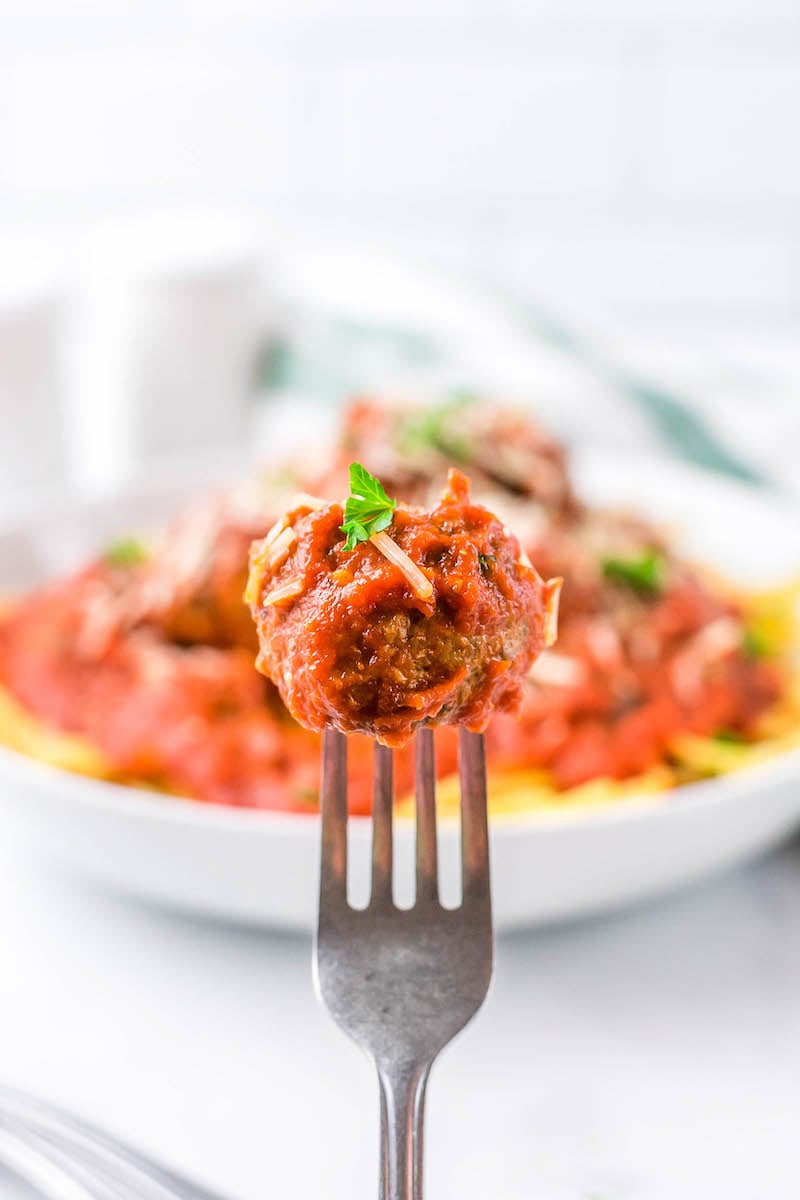 Meatball on a fork with a bite taken out of it.