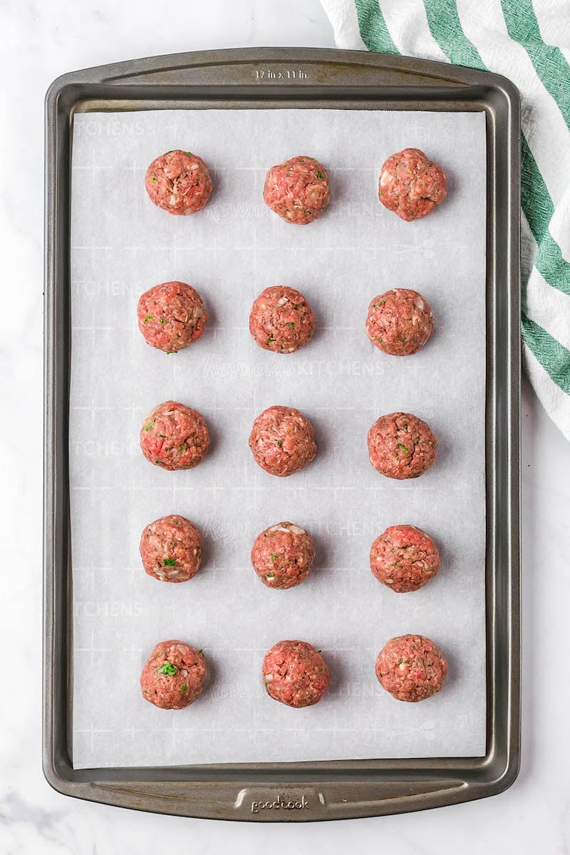 15 ground beef meatballs on a pan.