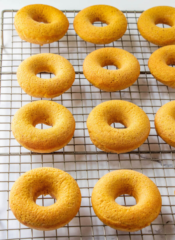 Pumpkin donuts on a cooling rack.