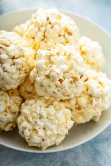A plate is holding a pile of marshmallow popcorn balls