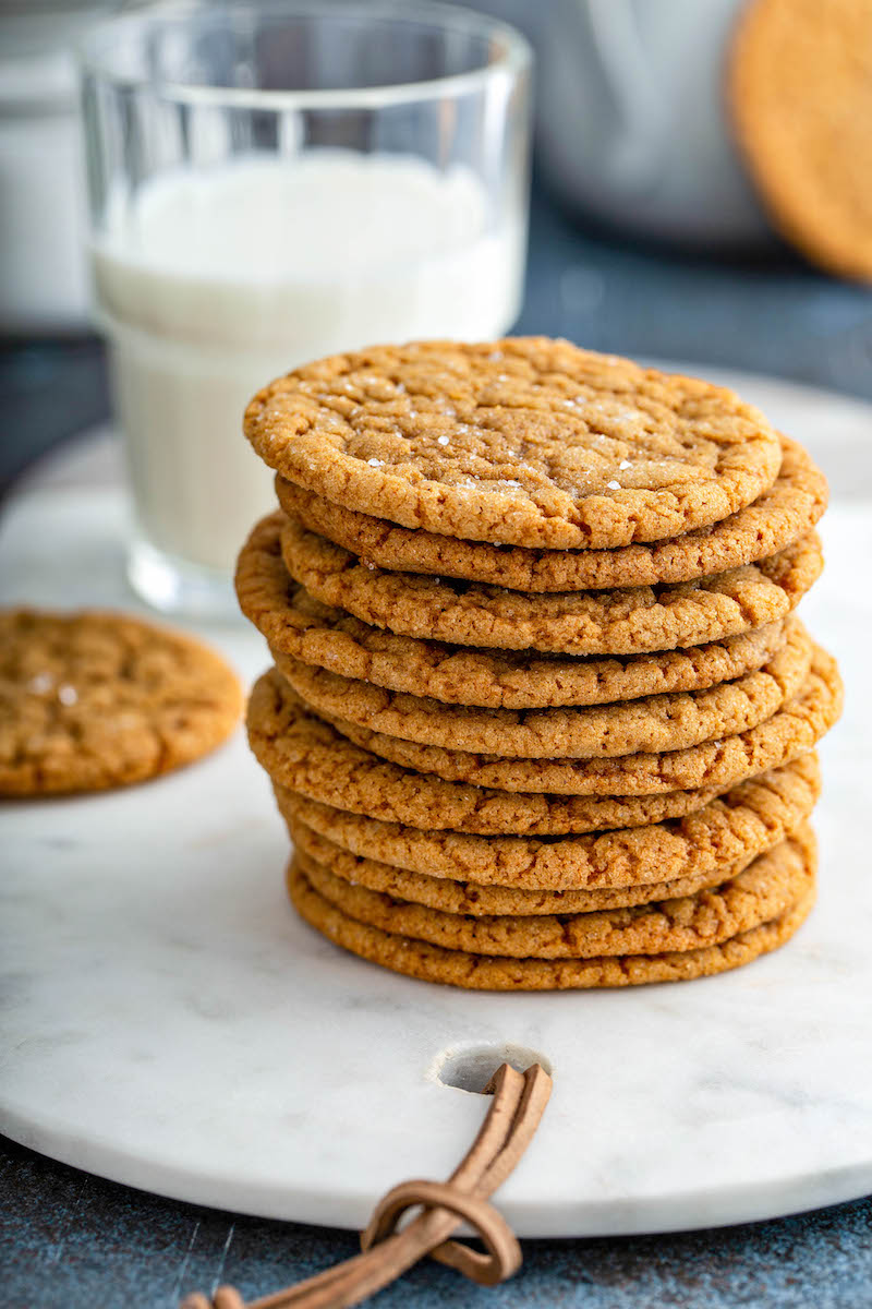 Stack of molasses cookies with a glass of milk.