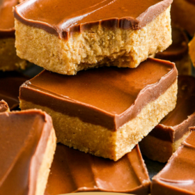 Up close image of chocolate peanut butter bars stacked on top of each other with wording on top for pinterest.
