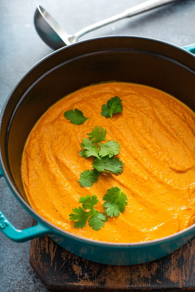Pumpkin soup in a stock pot with cilantro.
