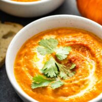 Bowl of pumpkin soup with chopped cilantro.