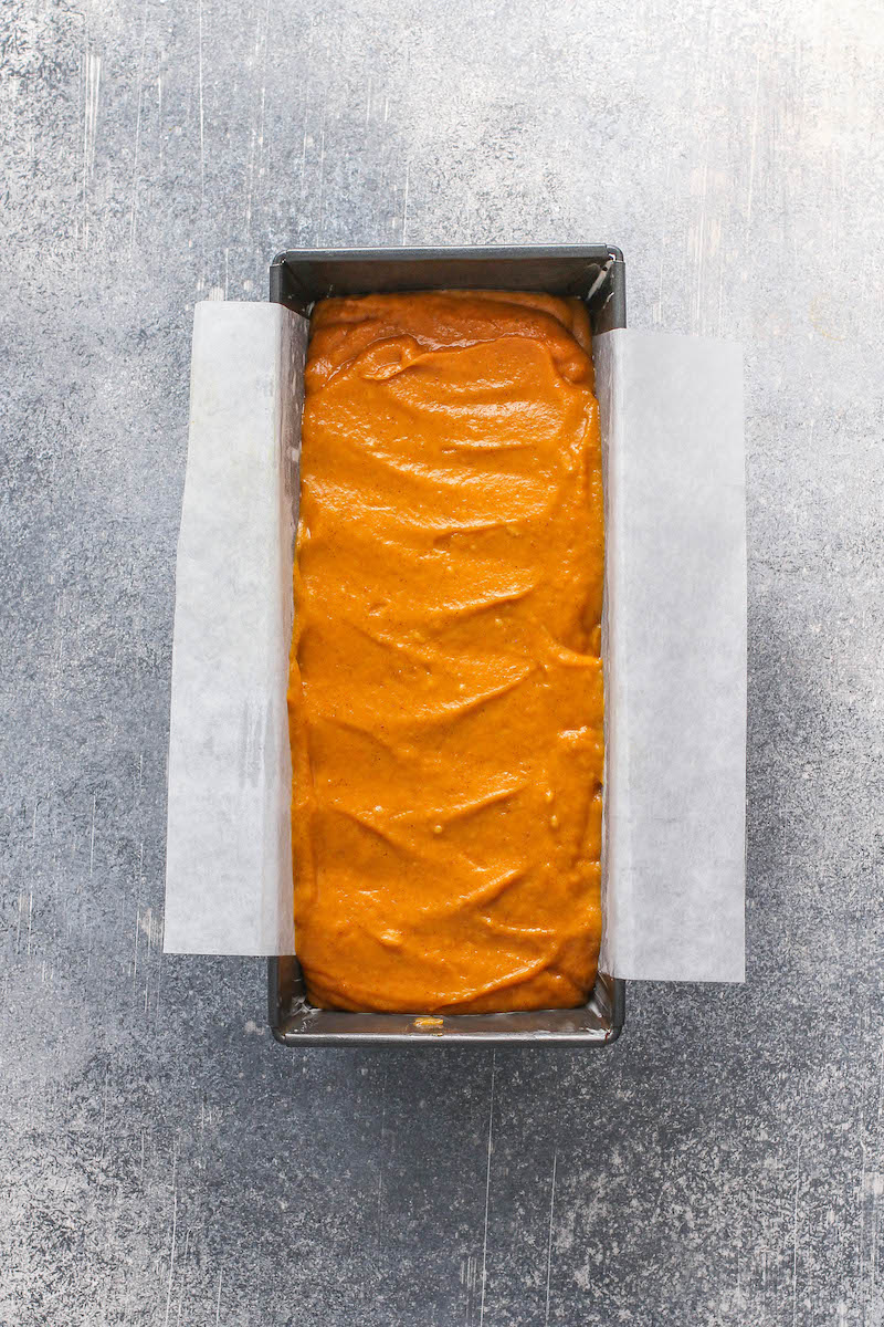 Unbaked pumpkin bread batter in a lined loaf pan