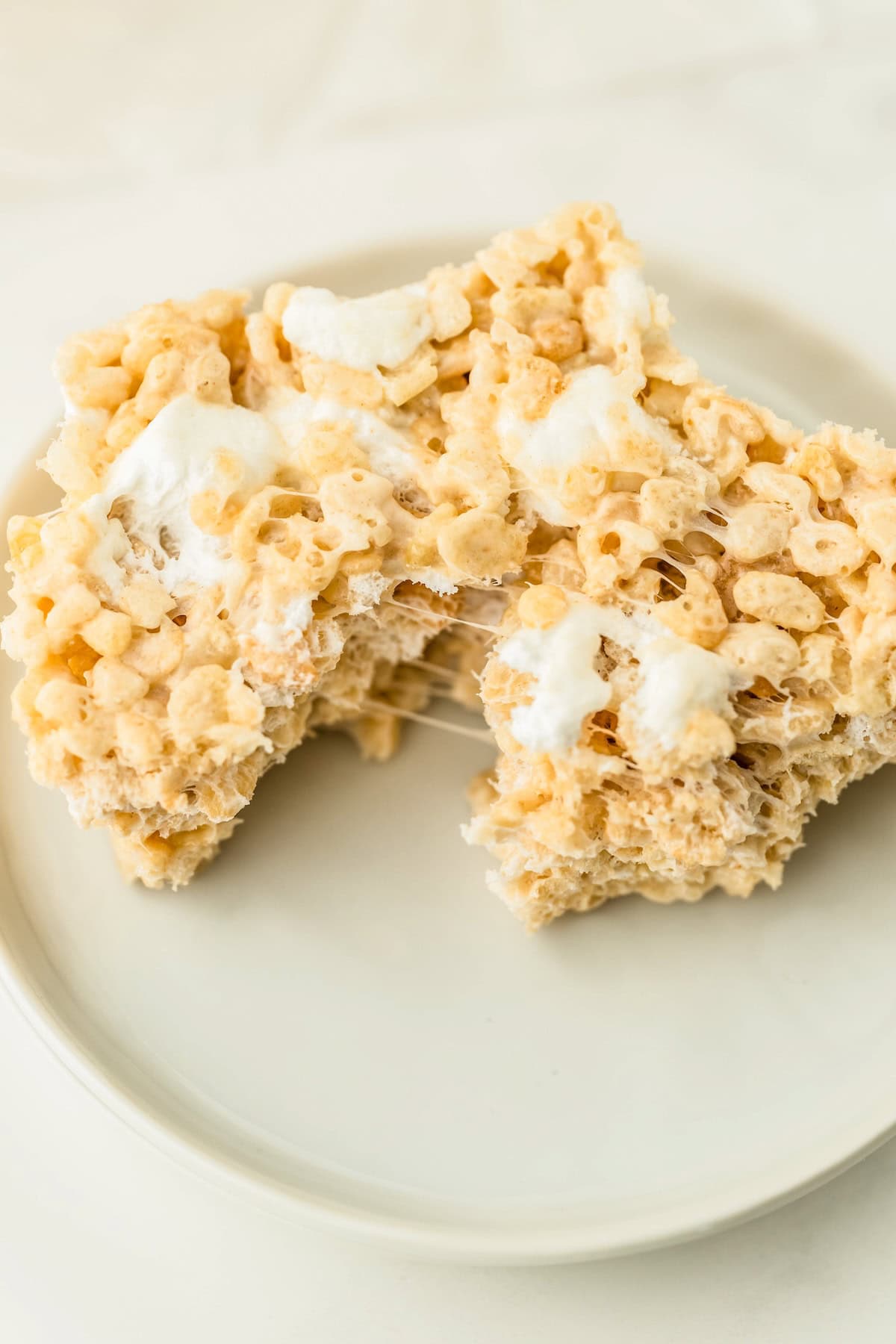 A close-up of a rice crispy treat being pulled apart to show the gooey center.
