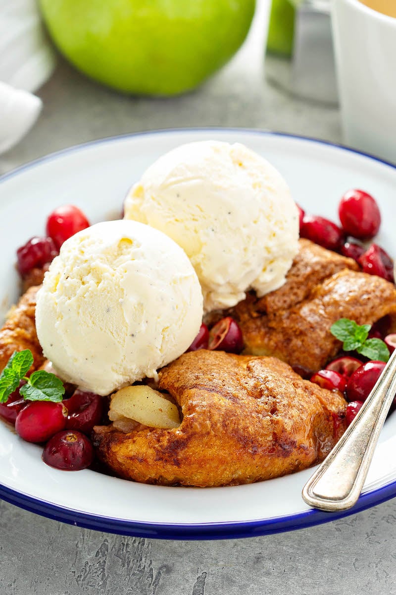 Vanilla ice cream with apple dumplings and cranberries.