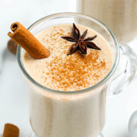 Glass of eggnog with a cinnamon stick.