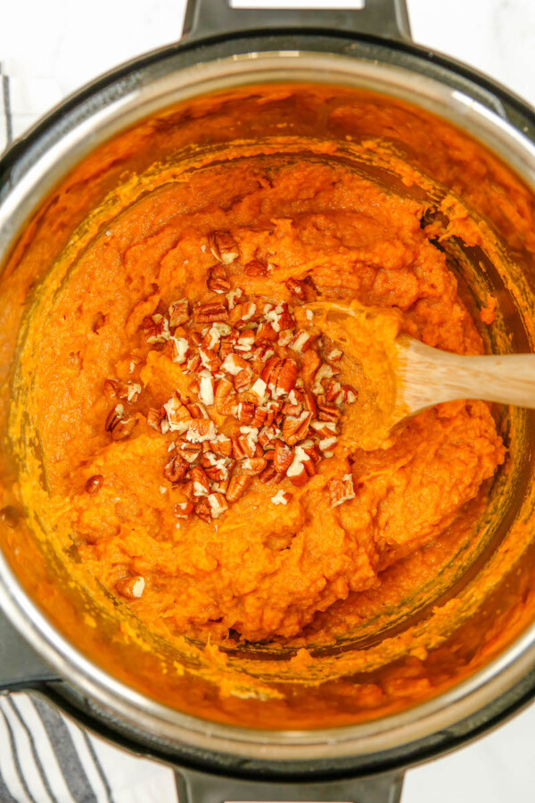Mashed sweet potato in the instant pot with pecans.