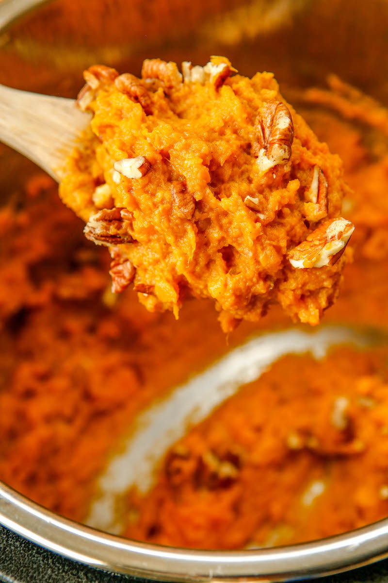 Spoonful of maple mashed sweet potato with pecans.