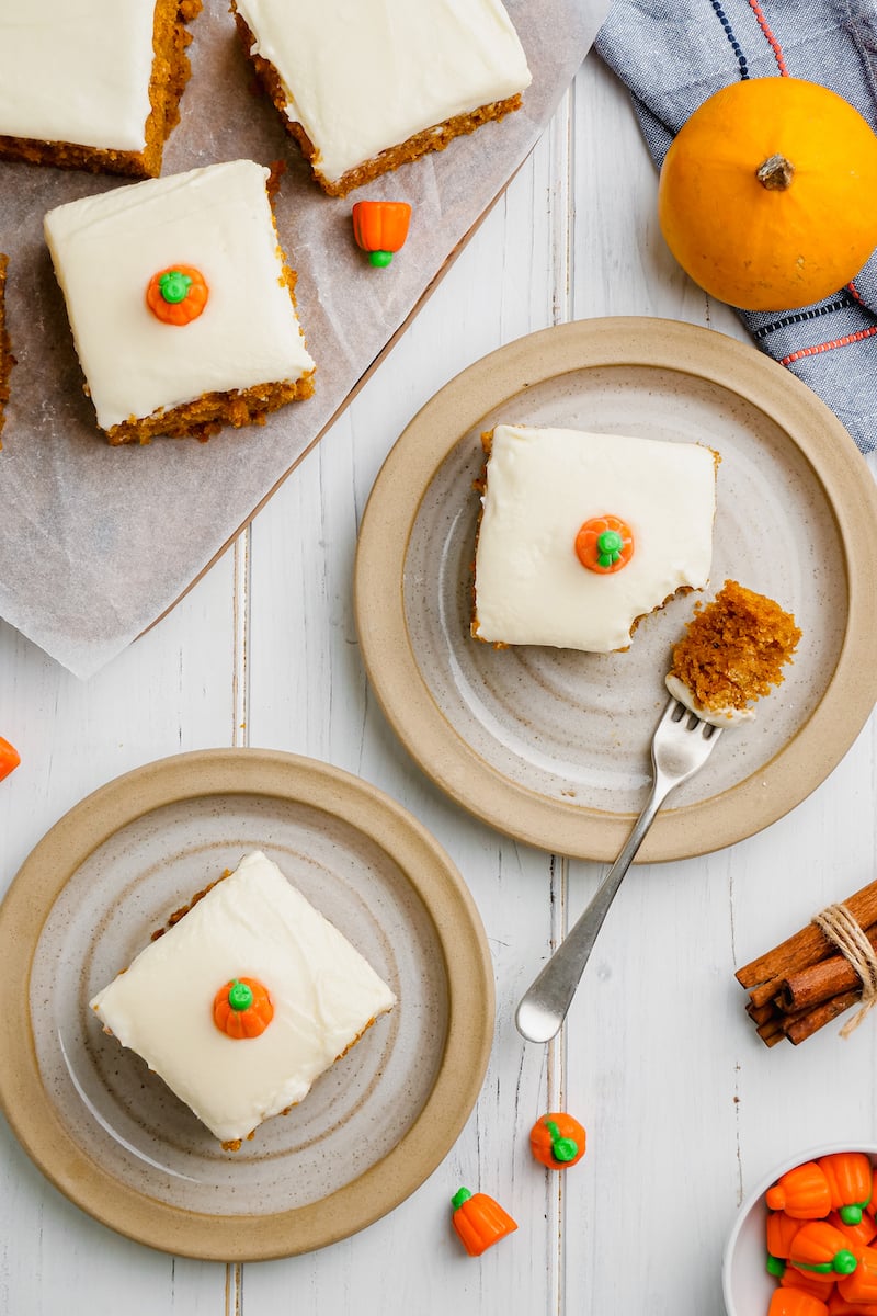 Two pumpkin bars are plated on a white surface