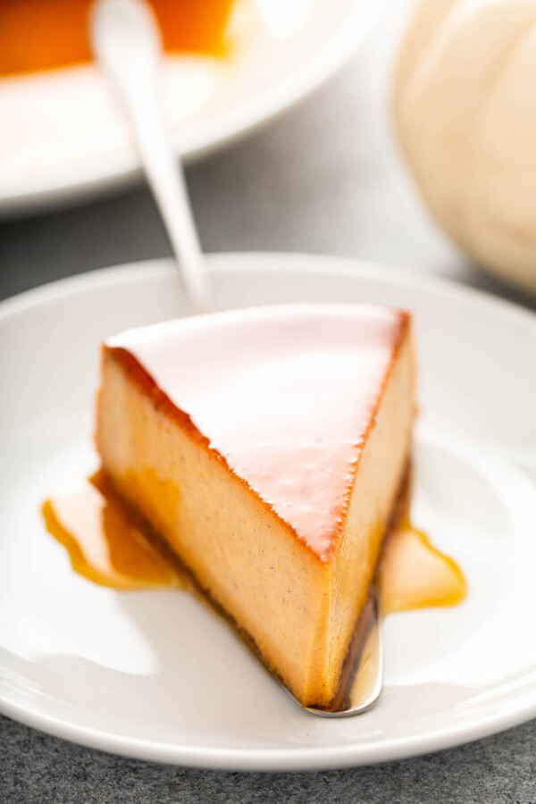 A piece of pumpkin flan is placed onto a white plate