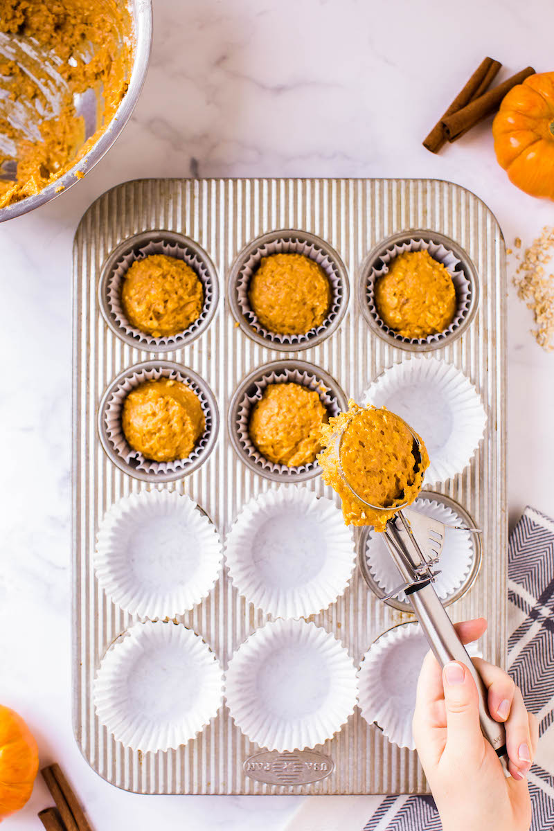 Pumpkin muffin batter in a muffin tin.