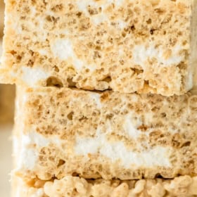 Three thick, stacked rice krispie treat bars with a gooey, soft texture. Text at the top reads, The Best Soft Chewy Rice Krispie Treats, and at the bottom, The Novice Chef.
