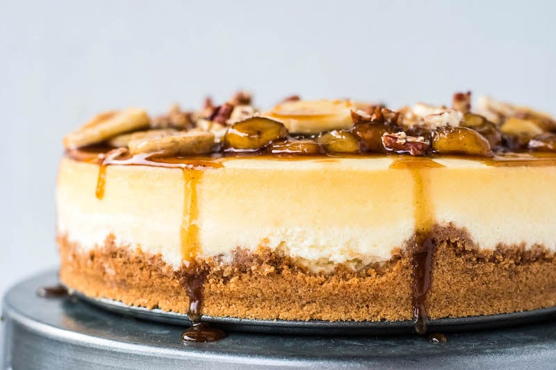 Bananas foster cheesecake on a cake platter.