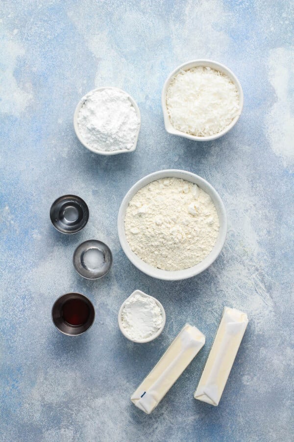 The ingredients for the cookies are spread out on a blue surface. 