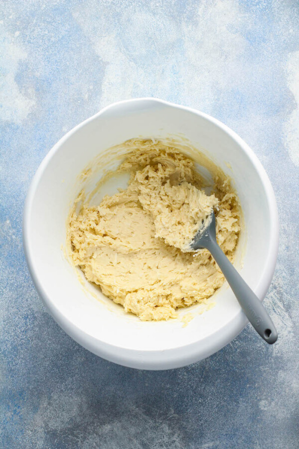 Cookie dough is mixed in a white bowl.