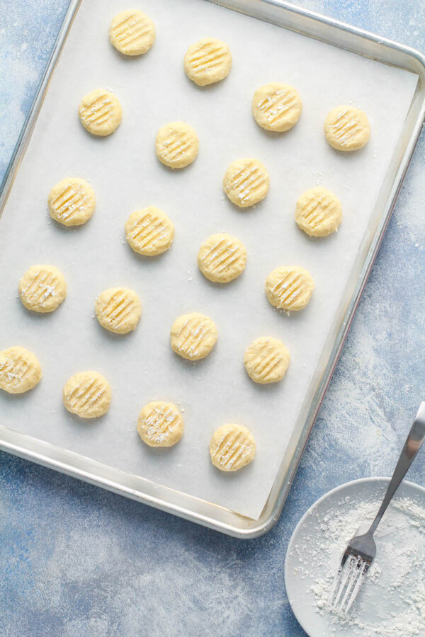 Coconut Whipped Shortbread Cookie dough is placed on a prepared baking sheet.