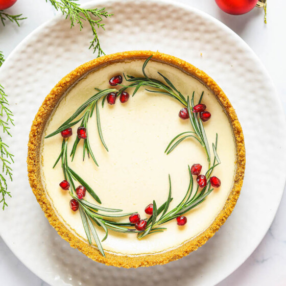 Eggnog cheesecake with pomegranates and rosemary.