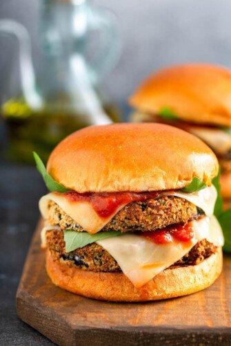 An Eggplant Parmesan Sandwich is placed on a wooden surface