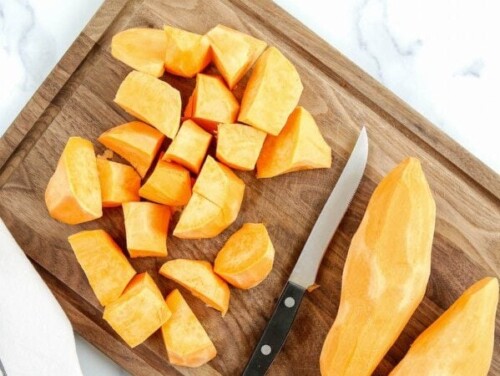 Peeled diced sweet potatoes on a cutting board