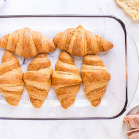 6 croissants in a glass pan.