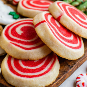 Pinwheel cookies on a cookie board with other Christmas cookies.