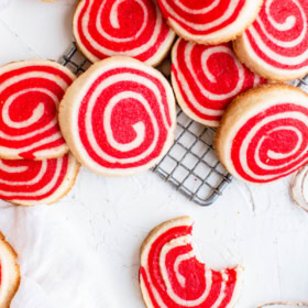 Overhead image of pinwheel cookies on a cookie cooling rack and marble countertop.