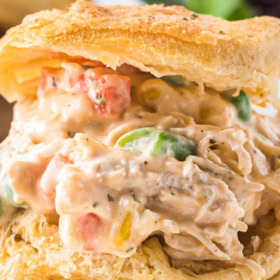 Up close image of chicken pot pie filling stuffed inside a biscuit.