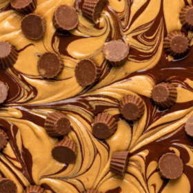 Overhead up close image of chocolate peanut butter bark with Reeses cups on top.
