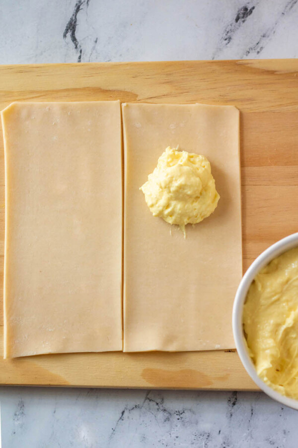 A dollop of yellow custard is placed on pie crust.