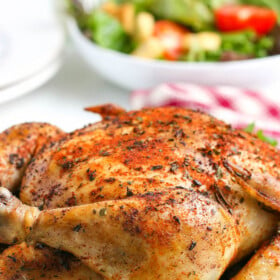 Juicy crockpot whole chicken with crispy skin on a serving platter.