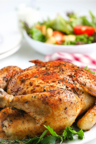 Juicy crockpot whole chicken with crispy skin on a serving platter.