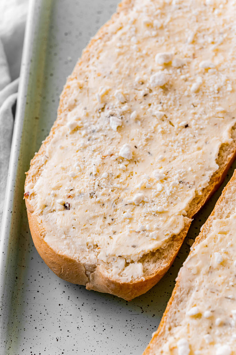 Bread with cheesy garlic spread on it.