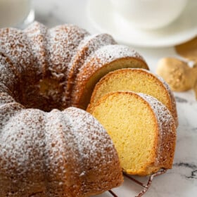 The orange rum bundt cake is sliced into, revealing a perfectly baked center.